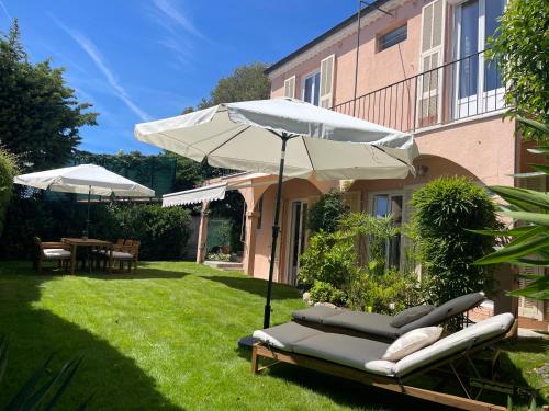 une terrasse avec un parasol, des chaises et une table dans l'établissement Completely renovated villa, à Cap d'Ail