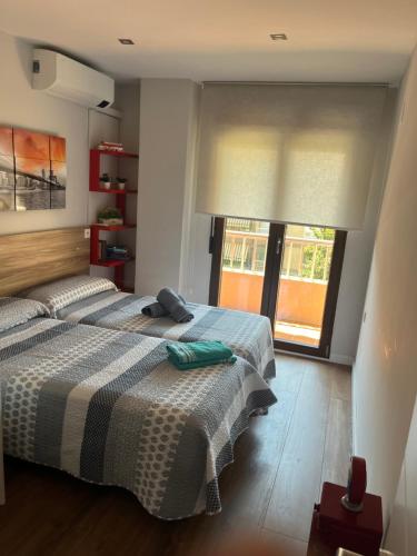 a bedroom with two beds and a window at PISO JUNTO PALACIO CONGRESOS Y METRO, CENTRICO CON PISCINA in Granada