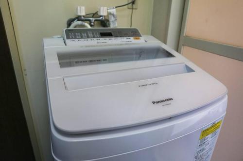 a machine is sitting on top of a refrigerator at 貸別荘せせらぎ in Taga