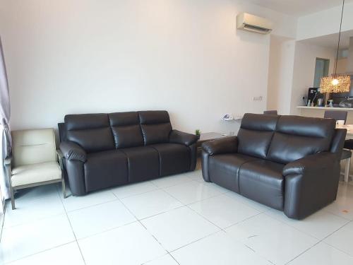 a living room with two leather couches and a chair at Seaview Condo 10pax #10minQueensbay #15minSpice in Bayan Lepas