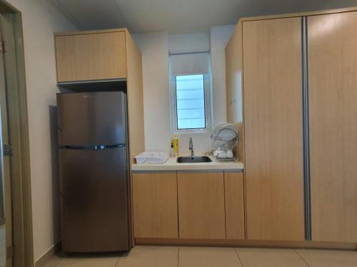 a kitchen with a stainless steel refrigerator and a sink at Seaview Condo 10pax #10minQueensbay #15minSpice in Bayan Lepas