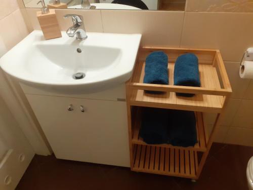 a bathroom with a sink and a toilet and blue towels at Słoneczny apartament z małym ogródkiem in Wejherowo