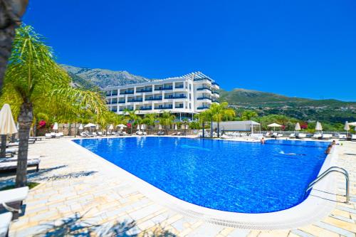 uma grande piscina em frente a um hotel em Elysium Hotel em Dhërmi