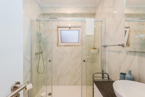 a bathroom with a shower with a sink and a toilet at Vista Mar in Quarteira