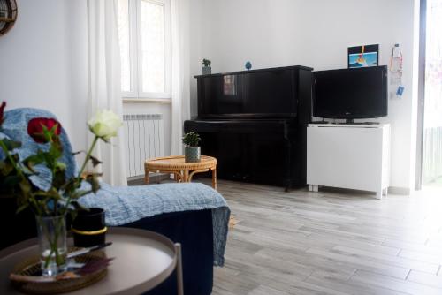 een woonkamer met een bank en een flatscreen-tv bij Holiday House ViscaUno in Nettuno