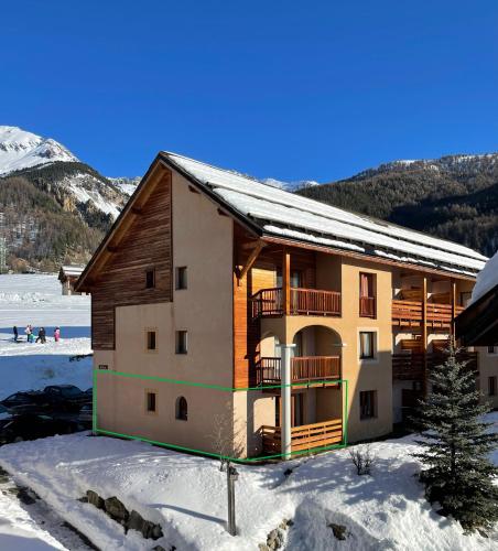 a building in the snow with a mountain in the background at Les granges d'Arvieux 701 in Arvieux