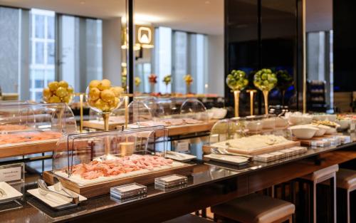 a buffet line with different types of food on display at Hotel The Square Milano Duomo - Preferred Hotels & Resorts in Milan