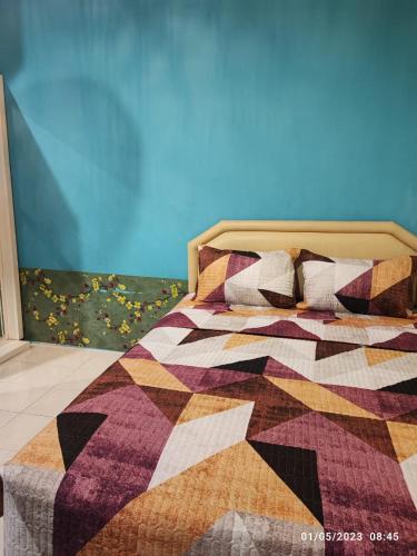 uma cama com uma colcha colorida e almofadas em Teratak HZ Homestay 2 em Kuantan
