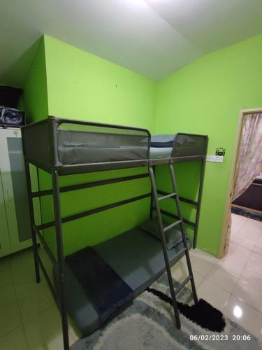 um beliche num quarto com uma parede verde em Teratak HZ Homestay 2 em Kuantan