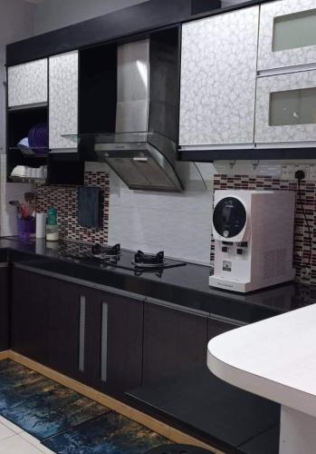 uma cozinha com um fogão e um micro-ondas em Teratak HZ Homestay 2 em Kuantan