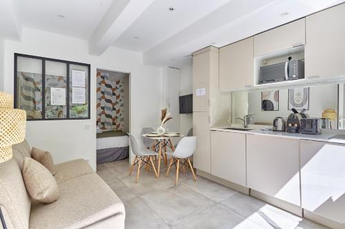 une cuisine et un salon avec un canapé et une table dans l'établissement Residence Le Marais by Studio prestige, à Paris