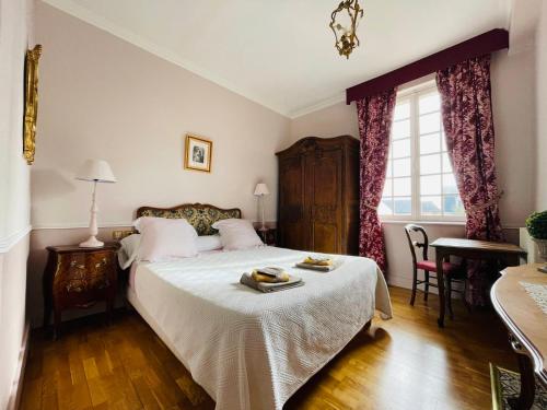um quarto com uma cama, uma mesa e uma janela em L’orangerie chambres d’hôtes em Motteville