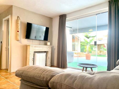 a living room with a couch and a large window at Villa AURA 500 metros de la playa in Torre de Benagalbón