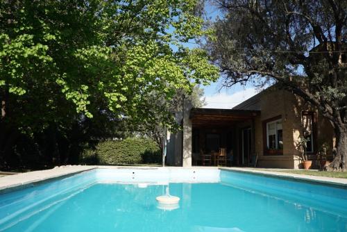 a swimming pool in front of a house at Magnifique studio éco relaxant avec piscine in Mendoza