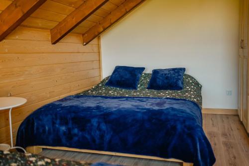 a bedroom with a bed with blue sheets and blue pillows at Beskidzka Oaza in Istebna