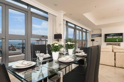 a dining room with a glass table and a couch at Luxury City Center Penthouse - Best Location in Galway