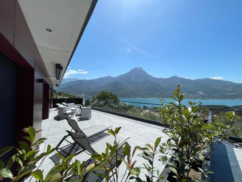 a balcony with a view of a lake and mountains at Les Restanques du lac in La Chapelle
