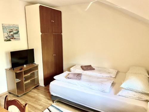 a small bedroom with a bed and a television at Apartman Željo 1 in Livno