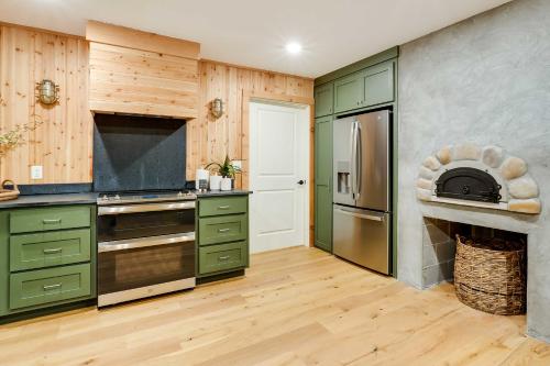 a kitchen with green cabinets and a stove at Spacious Home on Beaver Lake with Deck and Fire Pit! in Rogers
