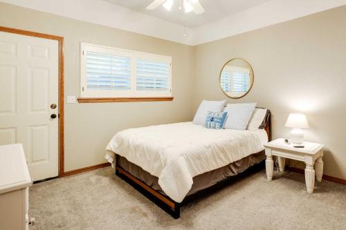 a bedroom with a bed and a mirror and a window at Spacious Home on Beaver Lake with Deck and Fire Pit! in Rogers