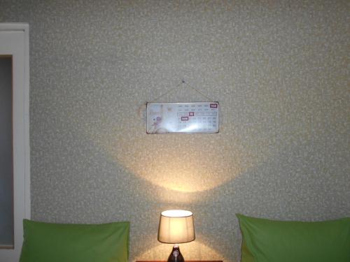 a bedroom with a bed with a light on the wall at Guest House Nise in Tbilisi City
