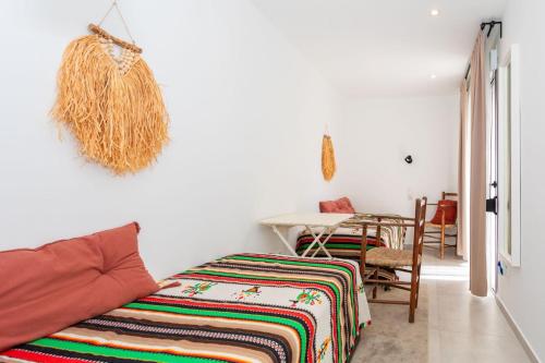 a bedroom with a bed and a table with a chair at La Cala Beach Home - beachfront few steps away from sandy beach in La Cala de Mijas