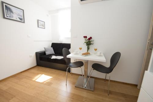 a living room with a table and chairs and a couch at Apartments Annya in Split