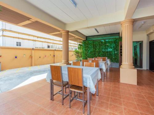 a dining room with tables and chairs and columns at Leda Seaview Room in Ban Saiyuan (1)