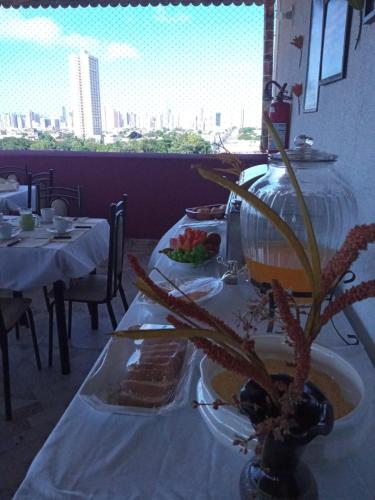 a table with a plate of food and a plant on it at Central Palace Hotel in Fortaleza
