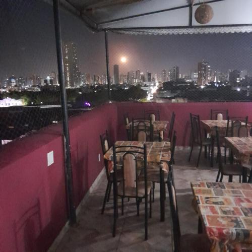 a restaurant with tables and chairs on a rooftop at night at Central Palace Hotel in Fortaleza