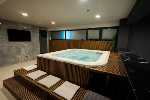 a bathroom with a jacuzzi tub and a television at Marinus Beach Hotel in Marina