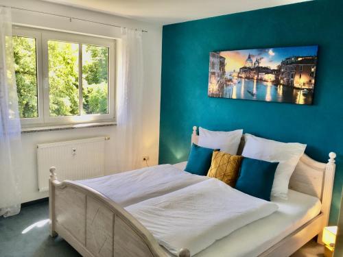 a bedroom with a bed with a painting on the wall at Schöne Gartenwohnung im Seenland in Wackersdorf