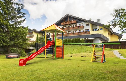 a playground in front of a building with a slide at Bergresort Seefeld in Seefeld in Tirol