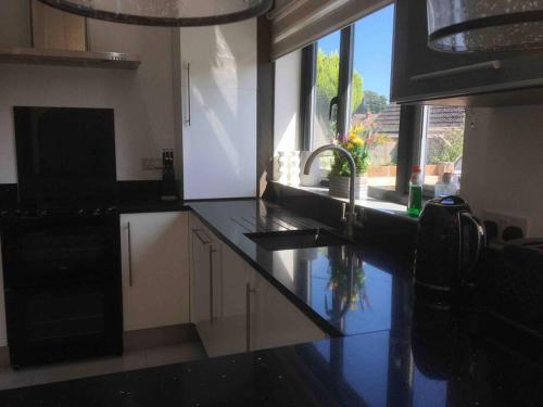 a kitchen with a black counter top and a sink at Cherry Cottage in West Mersea