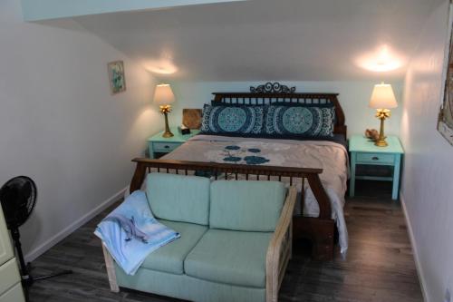 a bedroom with a bed with a chair and two tables at Mermaid Manor in Homosassa