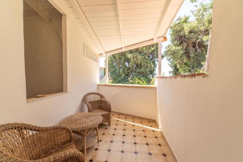 a room with wicker chairs and a window at Borgo Marino Plemmirio in Siracusa