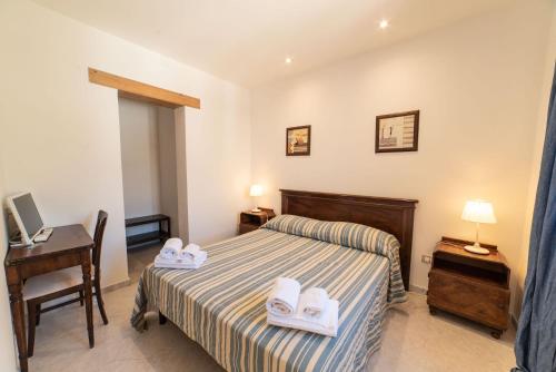 a bedroom with a bed and a desk and a computer at Borgo Marino Plemmirio in Siracusa
