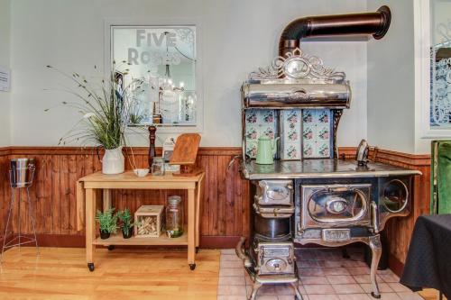 a kitchen with an old stove and a table at Auberge Presbytere Mont Lac-Vert in Hébertville