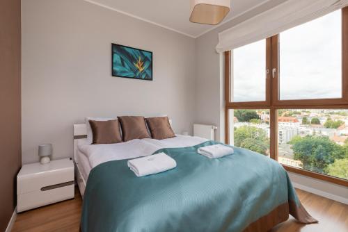 1 dormitorio con 1 cama grande y 2 toallas. en City Panorama Gdańsk Spacious Apartments by Renters en Gdansk