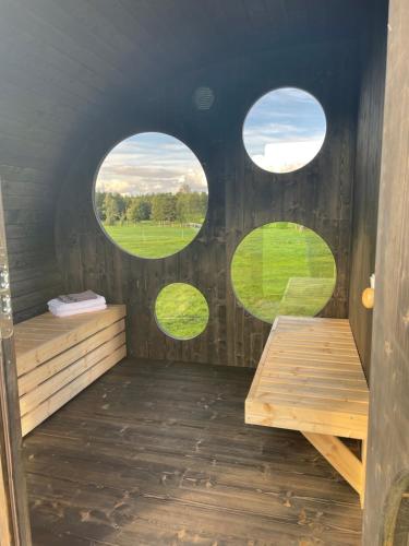 una sauna con 3 ventanas circulares en una cabaña en Flatmoen Natur Lodge, en Alta