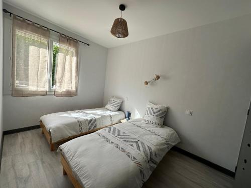 um quarto com 2 camas e uma janela em Appartement lumineux em La Bâtie-Neuve