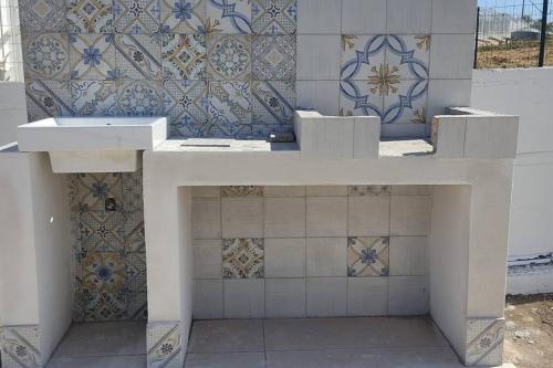 um lavatório branco sentado em cima de uma parede de azulejos em AltamareA Casa vacanze em Brucoli