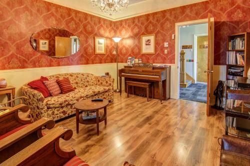 a living room with a couch and a piano at Auberge Presbytere Mont Lac-Vert in Hébertville