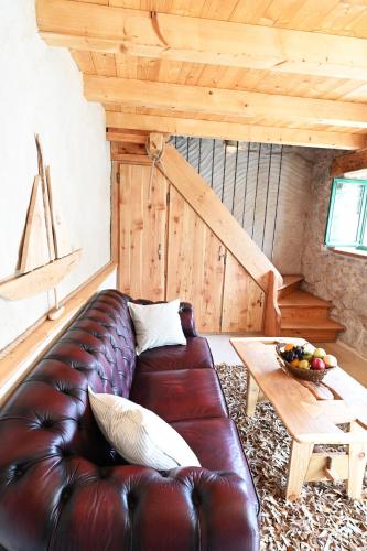 a living room with a leather couch and a table at Villa Teza Hvar in Hvar