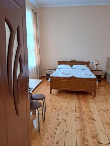 a bedroom with a bed and a wooden floor at Guest House David's B&B in Gyumri
