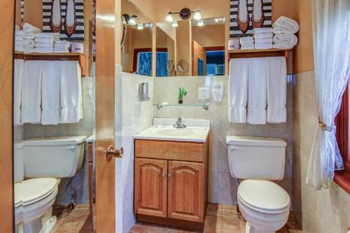 a bathroom with two toilets and a sink at Auberge Presbytere Mont Lac-Vert in Hébertville