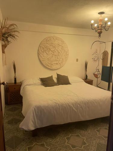 - une chambre avec un grand lit blanc et 2 oreillers dans l'établissement Casa om, à San Cristóbal de Las Casas