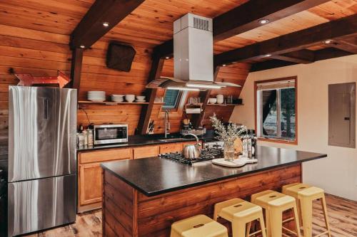 eine Küche mit Kühlschrank und Theke mit Hockern in der Unterkunft Majestic A-Frame on 5 acres! in Sisters