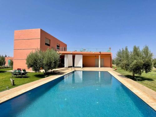 a swimming pool in front of a house at Villa de l'ATLAS in Marrakesh