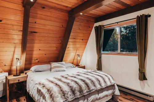 a bedroom with a bed in a room with wooden walls at Majestic A-Frame on 5 acres! in Sisters
